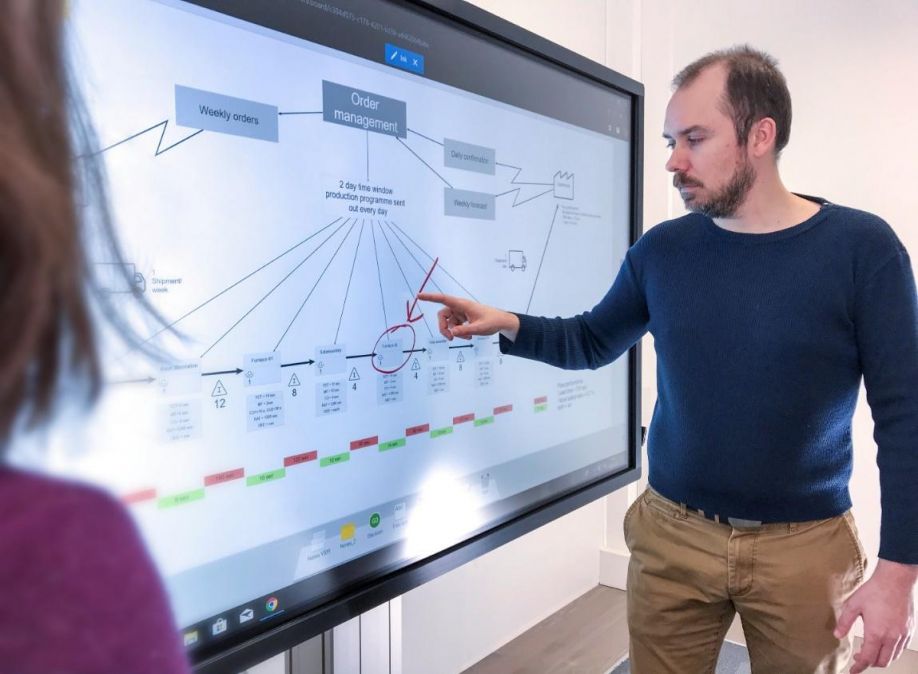 A person standing in front of a computerDescription automatically generated